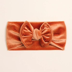 Texture détaillée du bandeau en velours pour bébé avec nœud doux en caramel