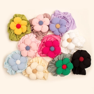 Infant striped beanie hats with large hollow floral ornaments in nine assorted colors