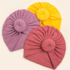 Detailed waffle texture of infant donut turban hats in purple, yellow and pink colors