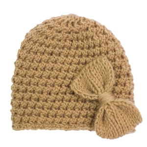 Détail du bonnet en grosse maille camel pour bébé avec un grand nœud décoratif