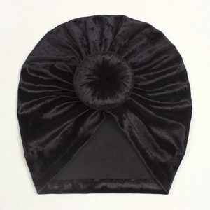 Detailed top view of a black velvet baby turban hat with a stylish donut knot decoration