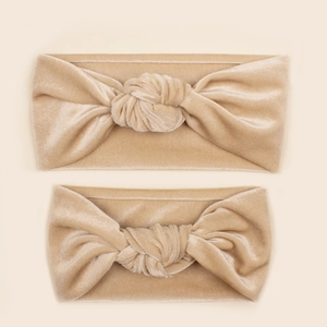 Detailed view of champagne gold velvet parent-child headband set with twisted knot design