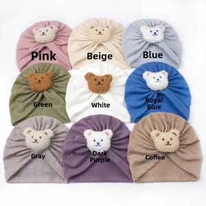 Detail view of baby turban hats with bear plush patches in nine distinct colors