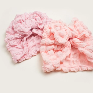 Pink bubble cotton baby turban hats with oversized bows on a clean off-white background