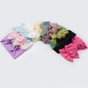 Set di dieci fasce per neonati colorate con grandi fiocchi ricamati a traforo su fondo bianco