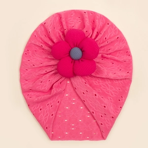 Detail of baby turban hat featuring a large pink fabric flower and hollow eyelet texture