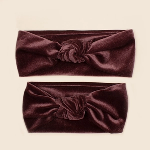 Detail of dark wine red velvet knotted headbands showing soft texture and twisted design