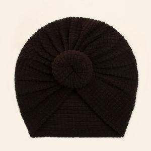 Detail of baby winter turban hat with waffle texture and large donut knot in dark brown