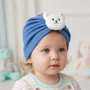 Detail of baby navy ribbed beanie featuring a cute white plush bear patch with embroidery