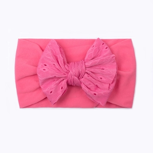 Dettaglio della fascia per neonata in nylon con grande fiocco in pizzo rosa