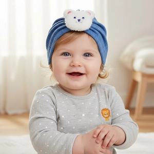 Close-up of baby wearing a navy blue knit beanie featuring a cute white teddy bear patch
