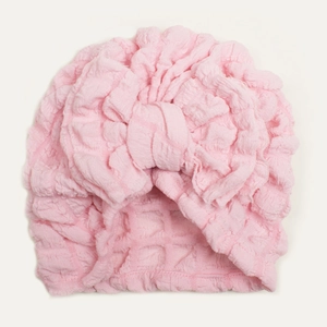 Detailed close-up of pink bubble fabric texture and large bow on baby turban hat
