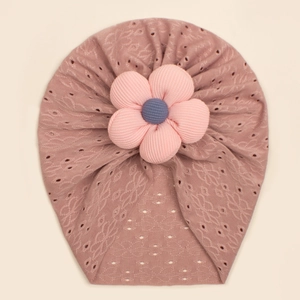 Detail of baby striped beanie with hollow texture and large 3D floral decoration