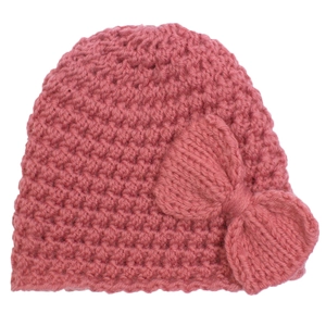 Détail d'un bonnet de bébé rose tricoté main avec un grand nœud au crochet sur fond blanc