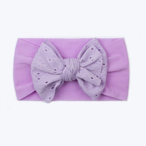 Dettaglio della fascia per neonati in nylon viola chiaro con fiocco in pizzo ricamato