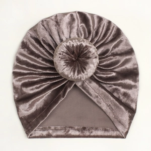 Detail of soft dark purple gold velvet baby hat featuring a stylish donut knot