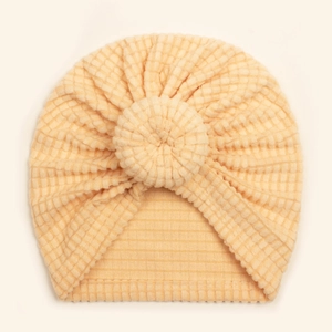 Close-up of cream yellow waffle knit baby turban hat with soft donut knot detail
