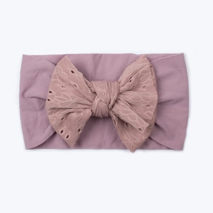 Texture dettagliata della fascia per neonati in nylon rosa antico con fiocco ricamato