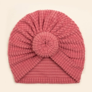 Detail of baby turban hat showing deep pink waffle knit fabric and soft donut knot
