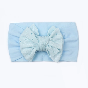 Dettaglio della fascia per neonati in nylon azzurro con grande fiocco in pizzo ricamato