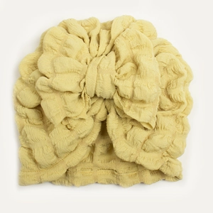 Close-up of bright yellow seersucker baby turban hat featuring a large decorative bow