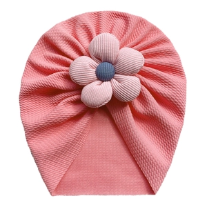 Pink ribbed baby turban hat with a large 3D flower decoration on white background