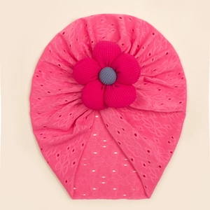 Detail of rose pink baby turban hat featuring a 3D fabric flower and breathable hollow knit