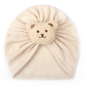 Close-up of baby turban hat featuring jacquard knit texture and cute 3D plush bear detail