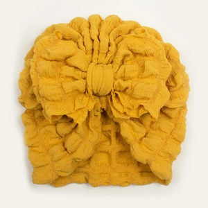 Ginger yellow waffle fabric baby turban hat featuring a large decorative bow