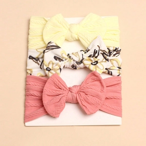 Detail view of 3pcs baby headbands with large bows in ribbed and floral patterns