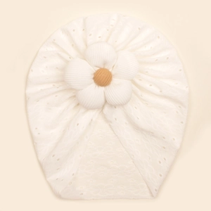Close-up of baby turban hat with hollow-out embroidery and 3D floral decoration