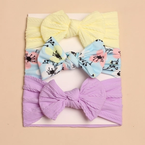 Detail of 3pcs baby bow headbands featuring knitted textures and floral patterns on card