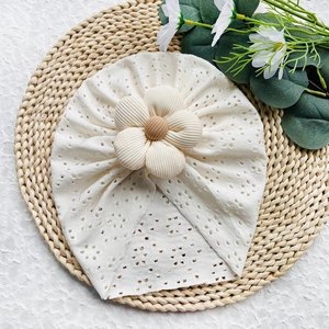 Dettaglio del turbante per neonati con ricamo traforato e decorazione floreale 3D grande