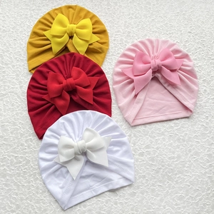 Vue détaillée des bonnets turban pour bébé en coton doux avec de grands nœuds déco