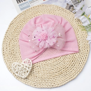 Close-up of pink baby beanie with large mesh flower and sequin star and moon details