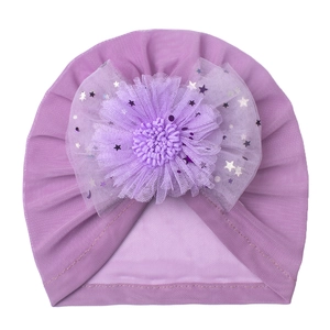 Detailed macro view of baby turban featuring purple mesh flower with silver star glitter