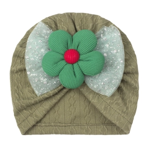 Detail of olive green knit baby turban with 3D fabric flower and sequined tulle bow