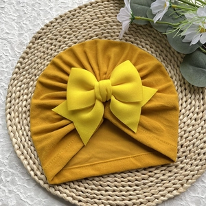 Détail du bonnet turban pour bébé jaune moutarde avec tissu doux et grand nœud