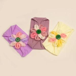 Dettaglio delle fasce per neonati in nylon morbido con fiori e bottoni vintage