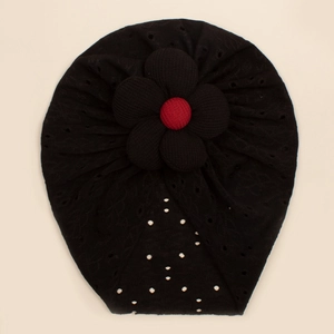 Detail showing breathable hollow dot fabric and large fabric flower on infant beanie