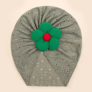 Detail of baby turban hat showing grey hollow-out knit pattern and large 3D fabric flower