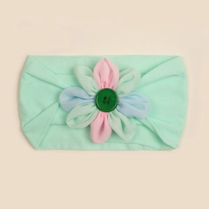 Dettaglio della fascia morbida in nylon per neonati con fiore di stoffa e bottone centrale