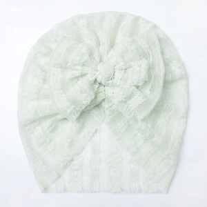 Dettaglio del cappello in pizzo verde menta per neonati con rete e fiocco decorativo