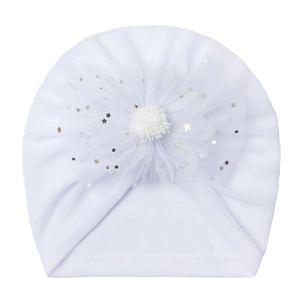 Close-up of white baby beanie featuring a large mesh flower with gold and silver sequins