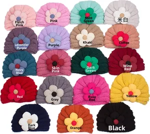 Dettaglio di cappelli per neonati in maglia con grandi fiori decorativi in tessuto 3D
