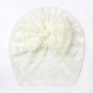 Soft white lace baby turban hat with a large bow detail for elegant infant photography