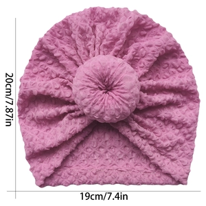 Pink waffle knit baby hat with center donut knot detail showing 19cm by 20cm dimensions