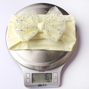 Detailed view of lightweight 16g baby headband with soft nylon mesh bow and silver sequins