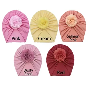 Set of five soft knit baby turban hats with large fabric flowers in various pastel colors
