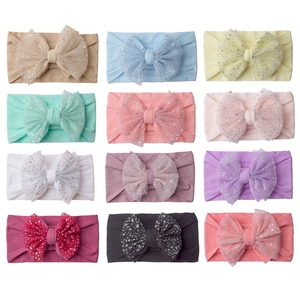 Set of 12 stretchy baby headbands with large sequin bow decorations in multiple colors